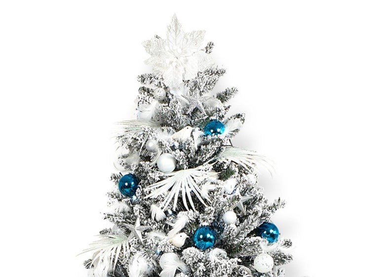Künstlicher Weihnachtsbaum mit Schnee und weihnachtlicher Dekoration aus Kugeln, Federn und Sternen für eine festliche Weihnachtsdekoration.
