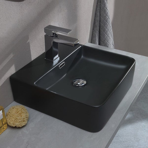 Modernes eckiges Aufsatzwaschbecken in Schwarz matt mit verchromter Armatur auf einem grauen Waschtisch.