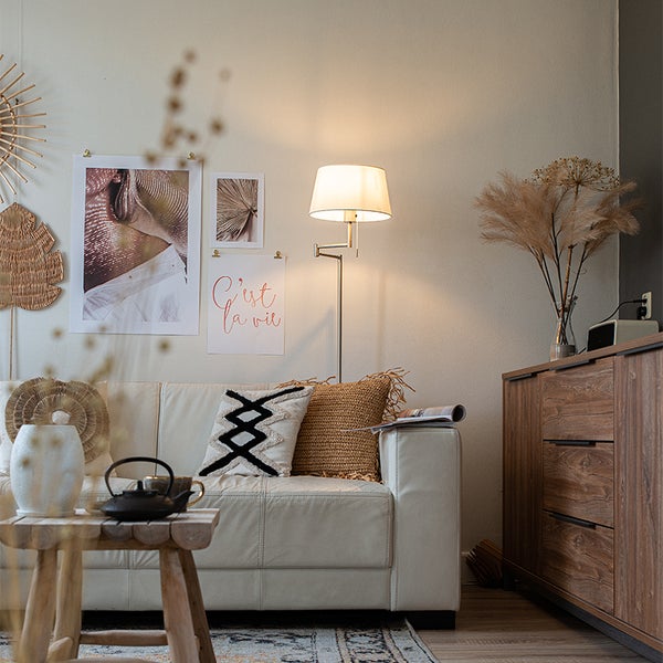 Wohnzimmer mit Sofa, Stehlampe und Dekorationen an der Wand