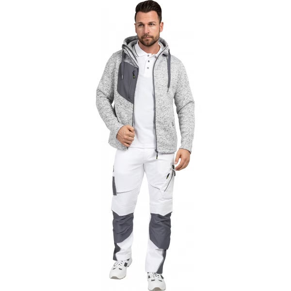 Mann in grauer Strickvliesjacke mit Kapuze, weißem Poloshirt und weiß-grauer Arbeitshose mit Kniepolstertaschen.