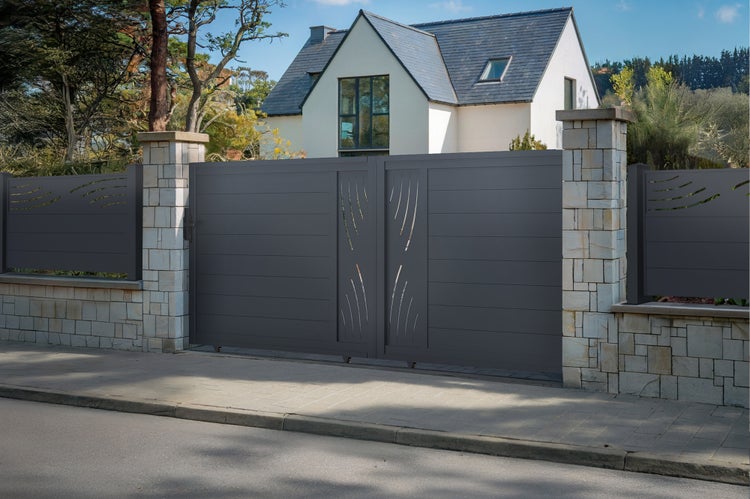 Modernes anthrazitfarbenes Doppelflügeltor aus Metall mit dekorativen Wellenausschnitten zwischen Steinpfeilern an einer Grundstückseinfahrt.