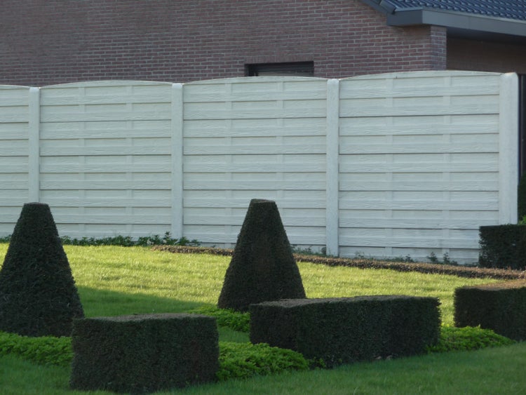 Gartenansicht mit Gartenzaun und geschnittenen Sträuchern.