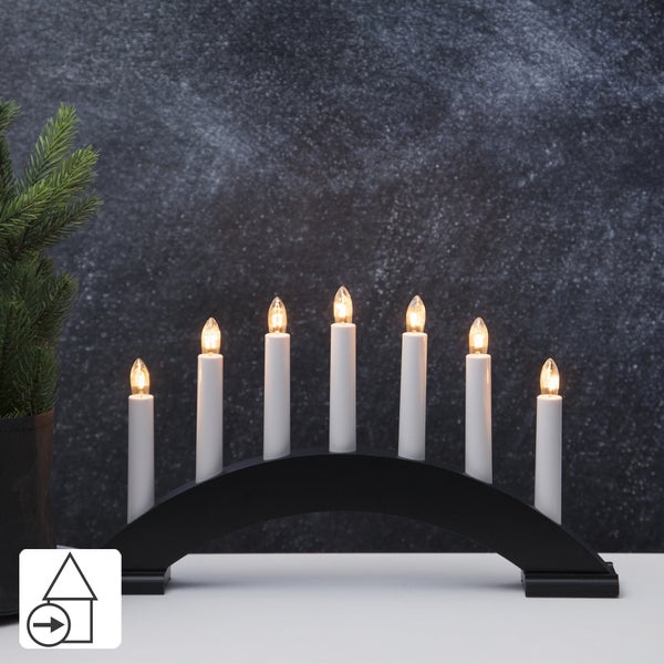 Dekorative Glühbirnen auf einem Holzkoffer mit Eukalyptuszweigen in einer Vase