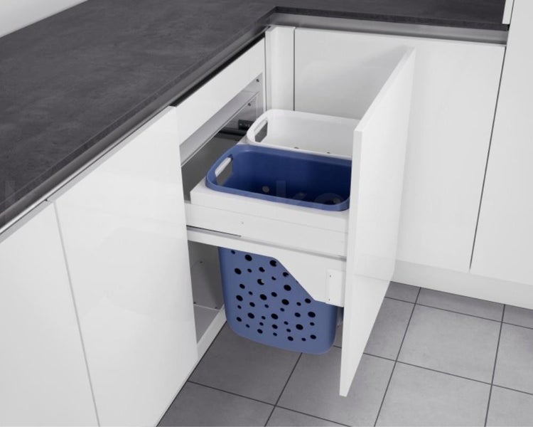 Ausziehbares Wäschesortiersystem in weißem Unterschrank mit zwei oberen Kunststoffbehältern und einem großen gelochten Wäschekorb.
