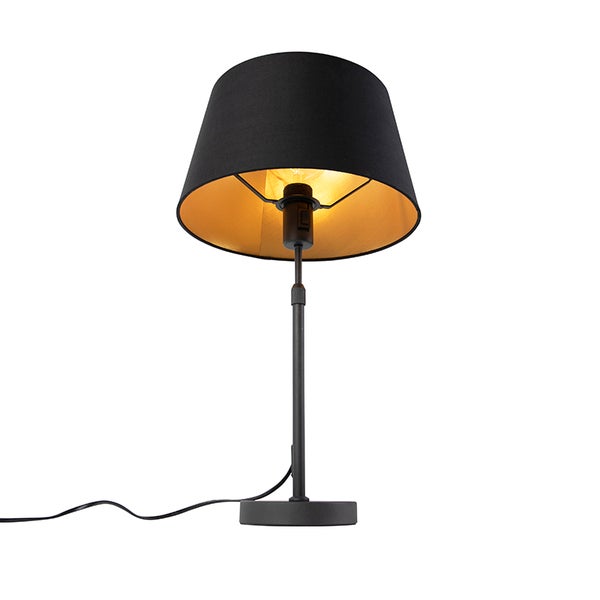 Tischleuchte mit schwarzem Textilschirm, goldfarbener Innenseite und schwarzem Metallfuß.