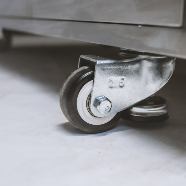 Lenkrolle aus Metall an einem Metallgestell montiert.