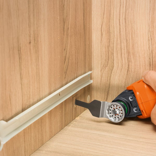 Mehrzweckwerkzeug im Einsatz zum Schneiden in einem Holzschrank