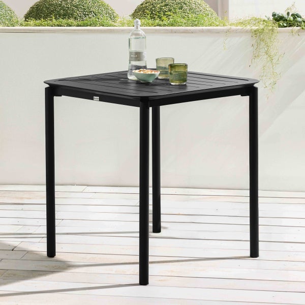 Quadratischer Gartentisch aus schwarzem Metall auf einer Terrasse mit Getränken, Oviala Logo.