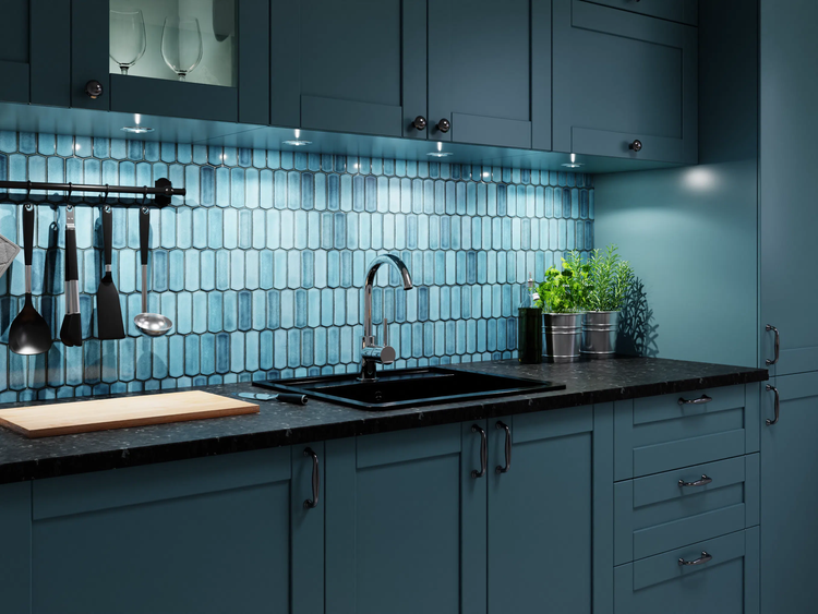 Moderne Küche mit dunkelblauen Schränken, schwarzer Spüle, Chromarmatur und blauem Fliesenspiegel in Hexagon-Optik mit Unterbaubeleuchtung.