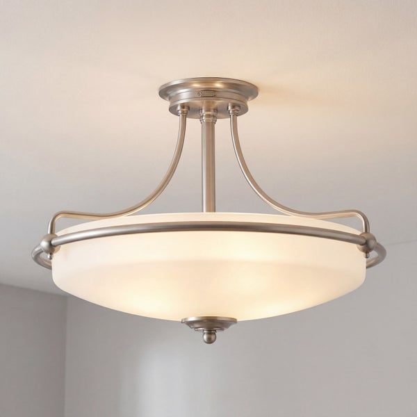 Halb-bündige Deckenleuchte mit mattiertem Glasschirm und gebürstetem Metallgestell, warm leuchtend.