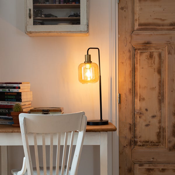 Dekorative Tischleuchte mit Glasschirm auf einem Schreibtisch