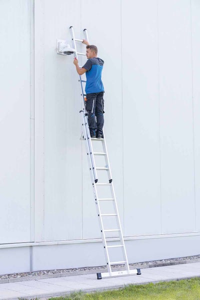 Mann arbeitet auf einer Aluminium-Mehrzweckleiter an einer Wand