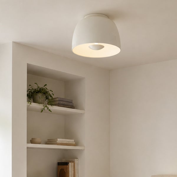 Moderne, kuppelförmige Deckenleuchte in einem minimalistisch eingerichteten Raum, die warmes Licht spendet.