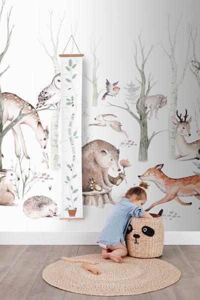 Szene mit Waldtapete, Wachstumsmesslatte, rundem Teppich und Kinderspielzeugkorb.