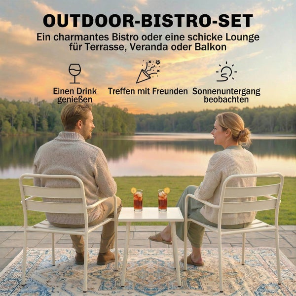 Ein Mann und eine Frau sitzen an einem weißen Outdoor Bistro Set aus Metall auf einer Terrasse mit Blick auf einen See bei Sonnenuntergang.