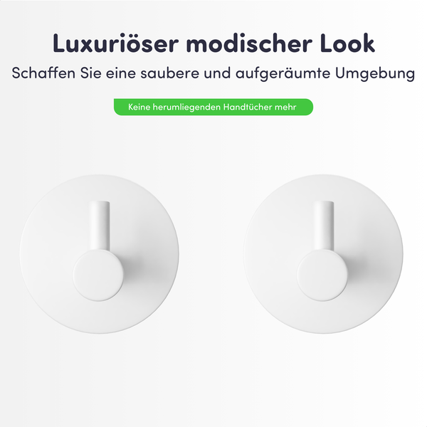 Zwei minimalistische weiße Wandhaken mit runder Basis für die ordentliche Aufbewahrung von Handtüchern.