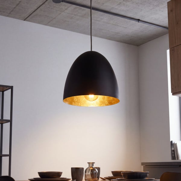 Kuppelförmige Pendelleuchte in Schwarz mit goldener Innenseite, aufgehängt über einem gedeckten Esstisch.