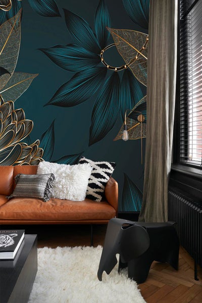 Wohnzimmer mit braunem Ledersofa, Kissen, Teppich und floraler Tapete