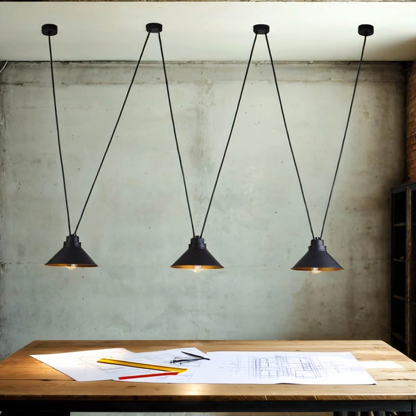 Vier schwarze Pendelleuchten über einem Holztisch mit Bauplänen