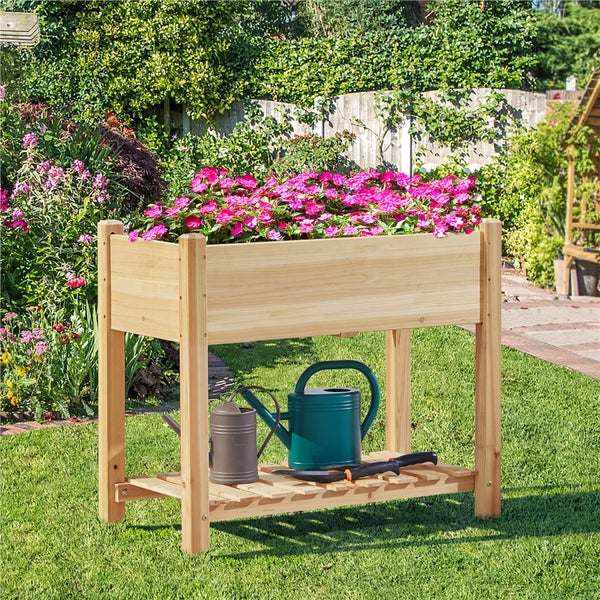 Hochbeet aus Holz mit Ablage und Gartenzubehör im Garten