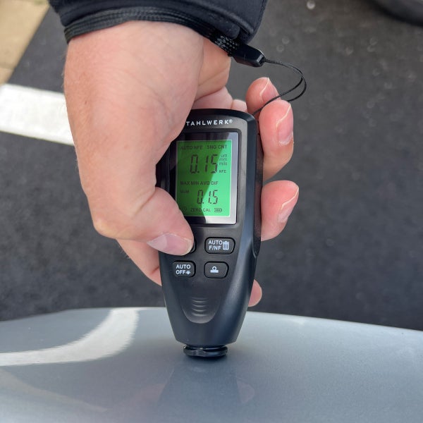 Eine Hand hält ein Tahlwerk Schichtdickenmessgerät zur Messung der Materialstärke.