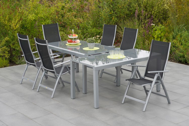 Gartensitzgruppe mit zwei Tischen, sechs Stühlen und Dekoration auf einer Terrasse