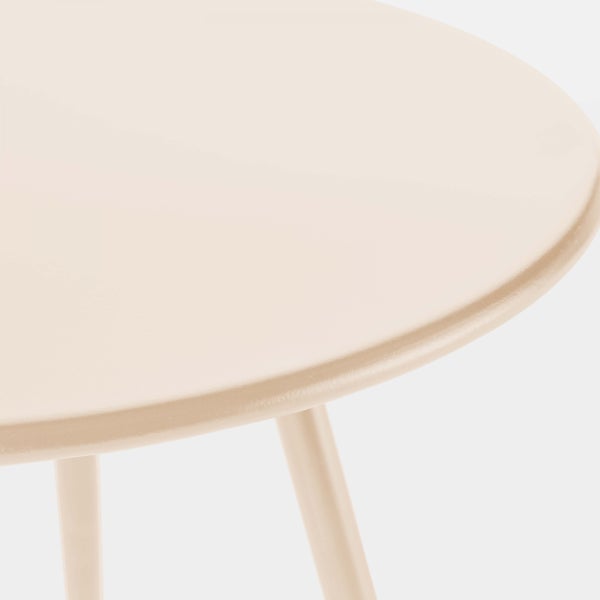 Detailaufnahme eines beigen runden Beistelltischs aus Metall
