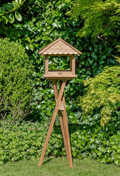Vogelhaus aus Holz auf Stativ im Garten