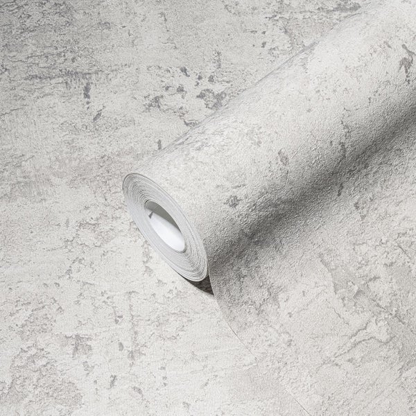 Wohnzimmer mit Sessel, Stehlampe und Beistelltisch vor einer grauen Wand