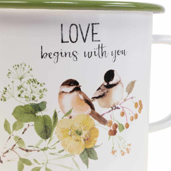 Tasse mit Vogel- und Blumenmuster sowie dem Schriftzug Love Begins With You