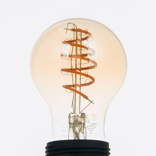 Smarte LED-Lampe in Birnenform mit spiralförmigem Filament und bernsteinfarbenem Glas.