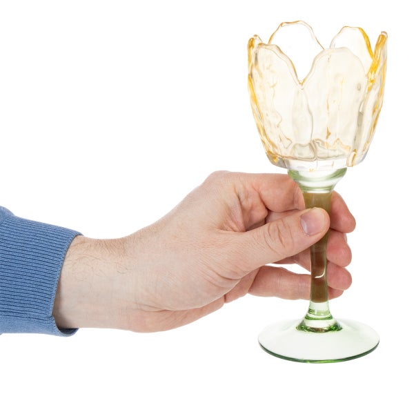 Hand hält Glas-Windlicht in Tulpenform