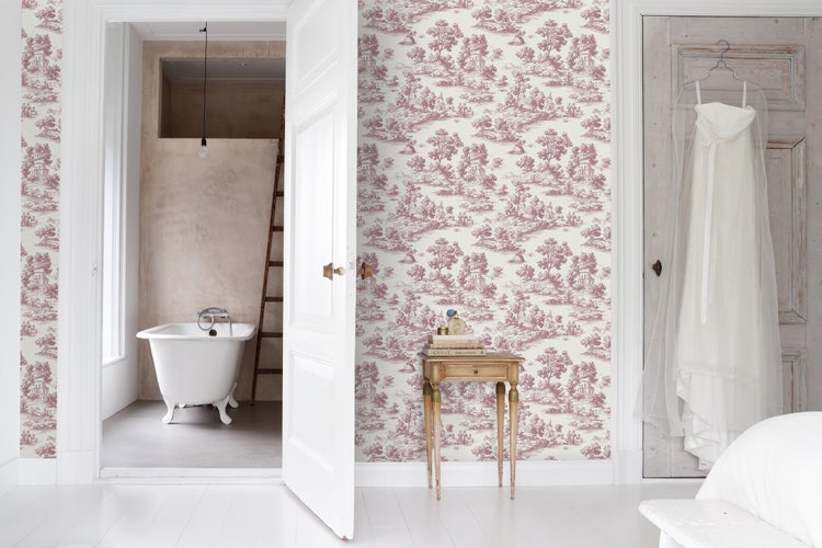 Vliestapete im Toile de Jouy Stil mit klassischen ländlichen Motiven in einem hellen Raum mit Blick auf ein Badezimmer mit freistehender Badewanne.