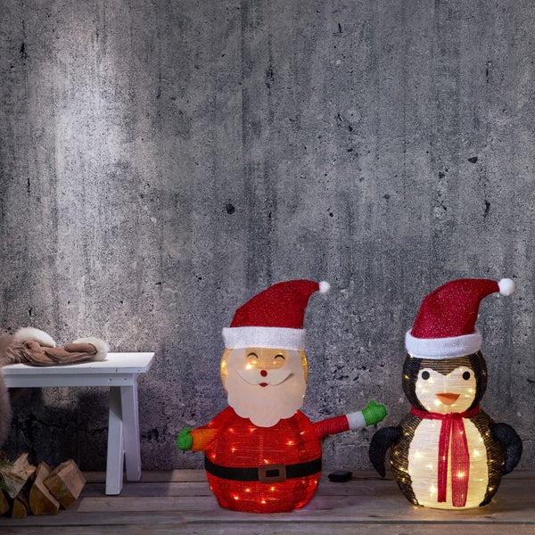 Leuchtender Weihnachtsmann und Pinguin als Weihnachtsdekoration
