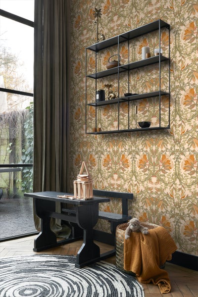 Ein Zimmer mit floraler Tapete, Regal, Tisch und dekorativen Accessoires.