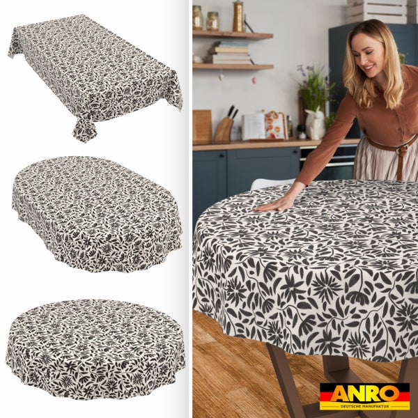 Abwaschbare Tischdecke mit schwarzem Blumenmuster in rechteckiger, ovaler und runder Ausführung, eine Frau am Küchentisch und ANRO Logo.