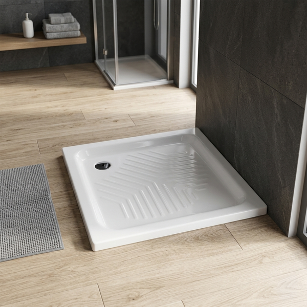 Quadratische Duschwanne mit rutschhemmender Struktur in einem modernen Badezimmer mit Bodenfliesen in Holzoptik und dunklen Wandfliesen.