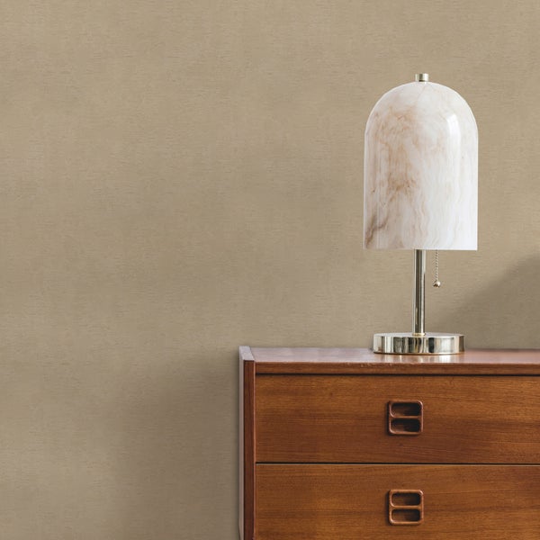 Strukturierte Tapete an einer Wand hinter einer Holzkommode mit einer Tischlampe aus Marmor.