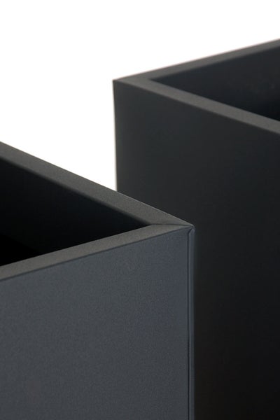 Detailaufnahme der Ecken von zwei quadratischen Pflanzgefäßen mit matter, strukturierter Oberfläche.