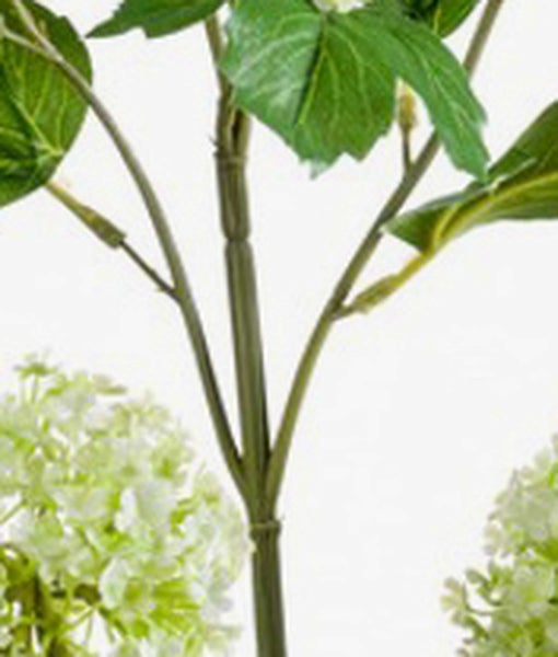 Künstliche Graspflanze in einem einfachen schwarzen Kunststofftopf.