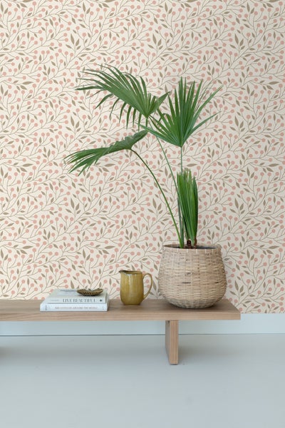 Ein Zimmer mit einer dekorativen Tapete, einem Holztisch, einer Pflanze in einem Korb und dekorativen Gegenständen.