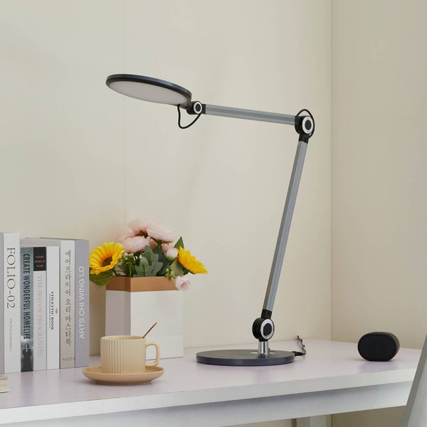 Sockel einer Schreibtischlampe mit induktiver Ladefunktion, gebürsteter Metalloberfläche und Schwenkgelenk.