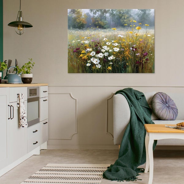 Wandbild mit Landschaftsmotiv von einer Wildblumenwiese an einer Wohnzimmerwand über einem Sofa mit Decke und Kissen.