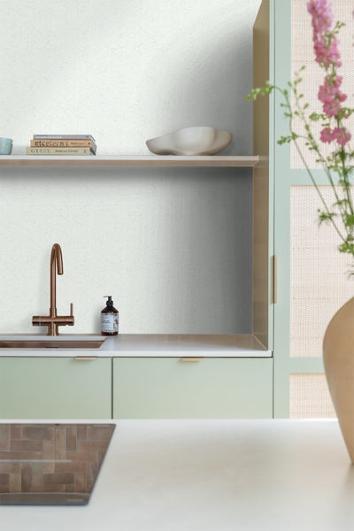 Detailaufnahme einer Küche mit Spüle, Armatur und Fliesenwand mit geometrischem Muster