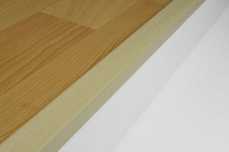 Treppenkantenprofil in Holzoptik an der Kante eines Laminatbodens.