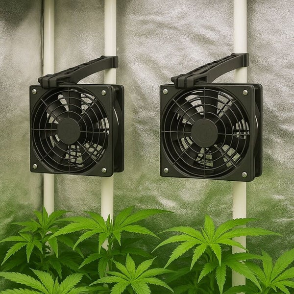 Zwei schwarze Clip-Ventilatoren für Grow-Zelte, befestigt an vertikalen Stangen über grünen Pflanzen in einem Zuchtzelt.
