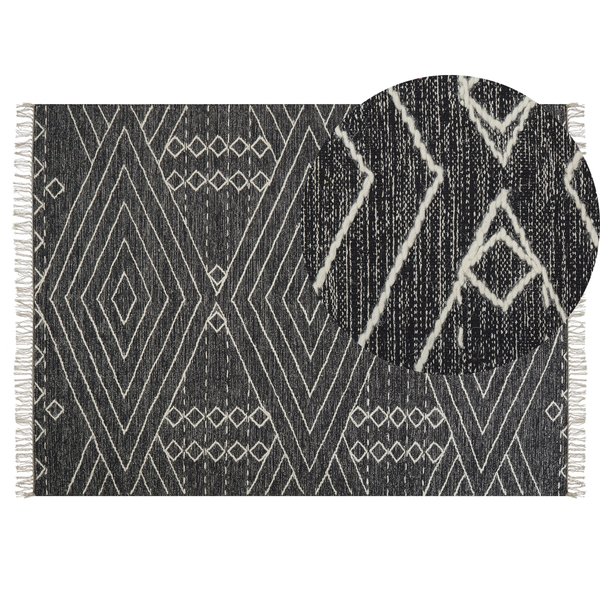 Schwarz-weißer flachgewebter Teppich mit geometrischem Rautenmuster und Fransen, inklusive Detailansicht der gewebten Textur.