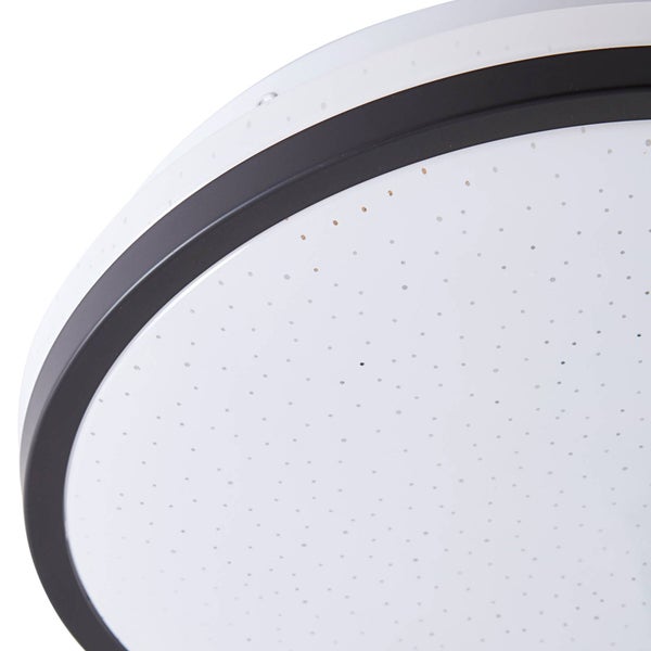 Nahaufnahme einer runden Deckenleuchte mit schwarzem Rand und weißem Diffusor mit Sternenhimmeleffekt.