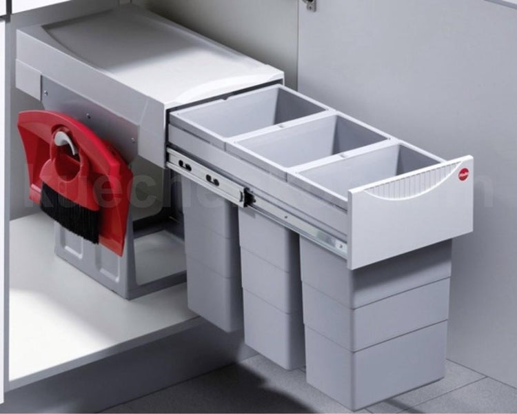 Einbau-Mülltrennsystem mit drei grauen Abfallbehältern, Auszugsschienen und einer seitlich befestigten roten Kehrgarnitur im Küchenschrank.