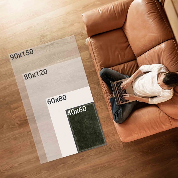 Teppichgrößenvergleich neben einer Person auf einem Sofa